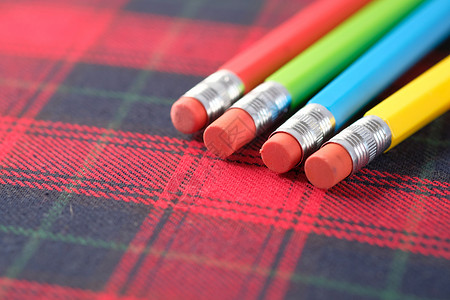 特写笔记本上的彩色铅笔标签家庭作业教育黄色摄影桌子学校绿色吼叫红色背景图片