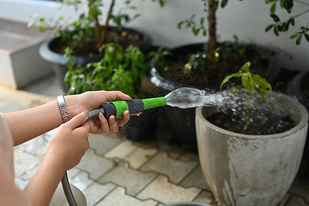 种植园艺 业余爱好 家庭生活概念 她们可以使用花园水管给女性亲手浇水背景