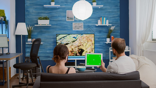 一对一对夫妇观看数字平板电脑的静态视频及绿色屏幕观看在线视频内容图片