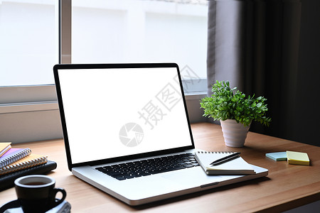 办公桌配件白色屏幕的笔记本电脑 木制桌上的咖啡杯广告工厂 家庭办公室工作场所概念背景