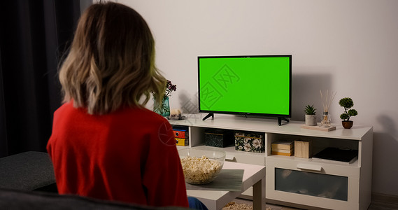 绿色电视文本框观看电视的女观众集中吃爆米花背景