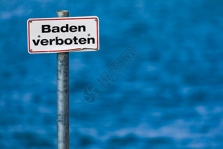 玫红色边框德文标志没有在湖前的一根柱子上游泳 有蓝水背景