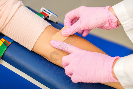 血标本护士在手臂上涂粘贴石膏伤口考试医师女性女士医生静脉专家捐款实验室背景