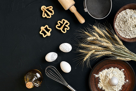 黑面粉面粉 鸡蛋 滚针 塑料烘烤形式 顶视图 黑桌上刀具木板工具甜点小麦勺子食物面包美食擀面杖背景