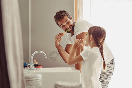 一位父亲和女儿这个家庭没有蛀牙 一位快乐的父亲和他的小女儿在浴室里一起洗手的镜头背景