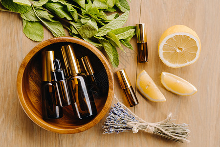 含柠檬 薄荷和熏衣油香的瓶装基本油 放在木质表面疗法水果瓶子芳香按摩香味木头皮肤治疗滴管背景