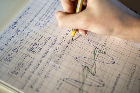 解决数学问题的学生桌子匿名写作笔记学习笔记本图形化图表铅笔家庭作业图片