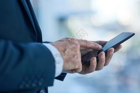 建立自信素材成功就在于建立正确的连接 一个商务人士在办公室的手机上发短信的近镜头 被拍到了背景