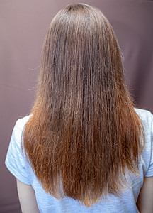 棕色头发的女人一个长长 直直和美丽的棕色头发的女孩 在家里照顾头发奢华光泽度长发发型理发师染色魅力洗发水女士黑发背景
