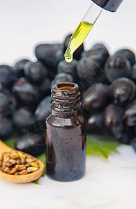 葡萄籽油在一个小瓶子里 有选择性的焦点蔬菜芳香木板身体草本植物头发种子药品治疗植物背景图片
