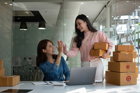 商业数字在线是小型企业目前在线商店的新起点 由两位女店主拥有一个仓库 用来给客户送货 中小企业企业家理念电脑商务技术互联网纸板成背景