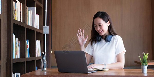 亚洲女学生在线学习班学习在线视频通话 zoom 老师 快乐的亚洲女孩用电脑笔记本电脑在线学习英语闲暇大学耳机家庭作业工作音乐学校背景