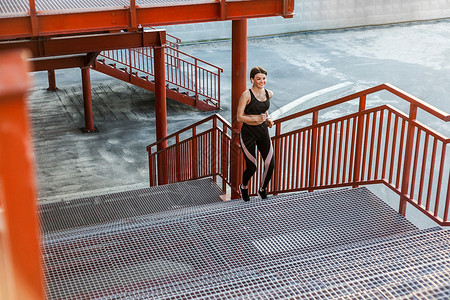 钢楼梯年轻的黑发女人和运动锻炼 在户外赛跑者女性活动运动员训练减肥跑步身体城市闲暇背景