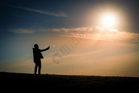 三鹰之森黄昏时站在山丘上的男人的休眠材料爬坡背景阴影美景天空三鹰日落公园例子背景