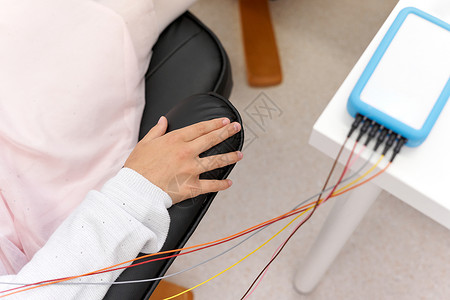 病人在生物反馈会话期间与装置连接的放松臂部位高清图片