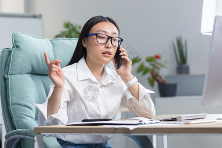 施工请注意安全在现代办公室工作的成功女商务人士 亚洲女性打电话 女工穿白衬衫秘书经理桌子标志成人顾问电话客户企业家微笑背景