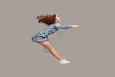 拿着荷叶女孩侧视女孩以全速加速冲浪 快速驾驶 在空中飘浮 模型飞得很快裙子黑发背景重力风暴飞行悬浮速度自由空气背景