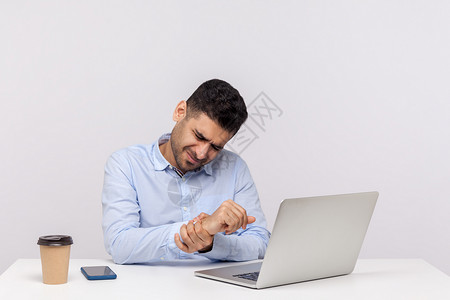 腕管综合征坐在办公室和工作着的情感男人风湿员工手腕职场创伤扭伤伤害手臂商业电脑背景