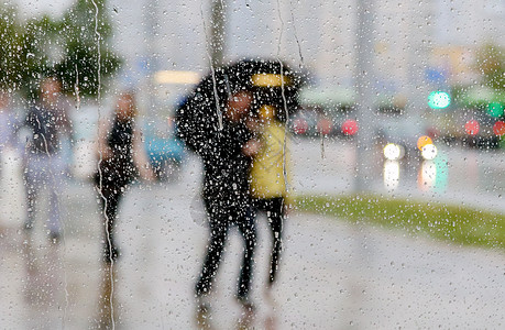 伞雨与带雨伞的人在窗口上的雨滴风暴环境气候行人天气液体温度团体飞溅雷雨背景