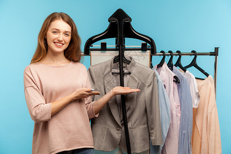 女人和蓝色背景的衣服贮存收藏衣柜女士零售市场女性造型师助手露齿背景图片