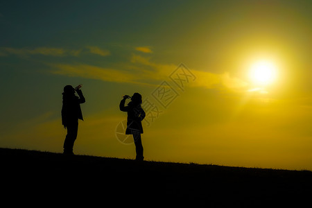 三鹰之森男男女女在黄昏山丘上饮水男人女士日落美景草原男性橙子水分爬坡天空背景