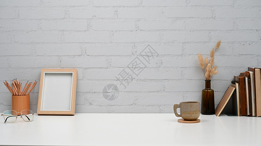 书墙创意素材图片框架 铅笔持有者 白桌上书籍和咖啡杯的创意工作空间背景