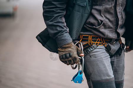 工人登山者准备在高度工作建造职业腰带男人绳索工业齿轮安全风险控制背景图片