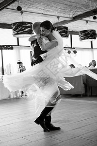 新娘和新郎的第一次婚礼舞马夫大厅套装日落地面舞蹈旋转餐厅裙子夫妻背景图片
