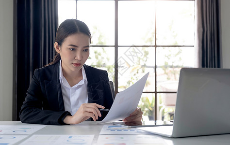 财税体制改革一位亚洲女性在现代办公室的平板电脑上工作的肖像 制作账户分析报告 房地产投资资讯财税制度概念公司桌子企业家经理自由职业者商业技术背景
