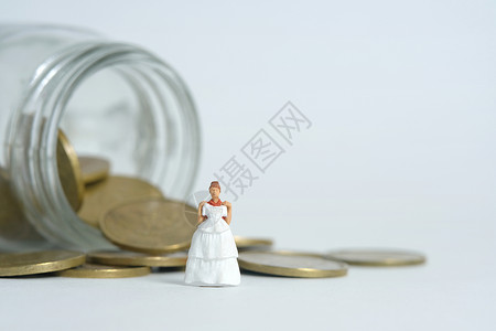 婚礼钱花素材新娘的婚纱预算 微型人物插图概念 妇女站在硬币钱罐之上 图像图片照片婚姻金融债务贷款经济储蓄马夫女士硬币传统背景