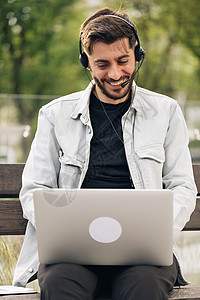 讲膝上型计算机 在线会议远程办公室聊天 虚拟培训概念的族裔商务人士 他们通过视频电话使用耳机进行交流 (b) 商业人戴耳机背景图片