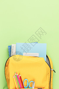 有笔记本和学习用品的黄色背包高清图片