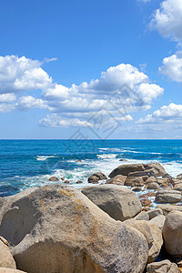 丰富多彩的岩石在南非开普敦坎普斯湾 在多云的蓝天背景和岩石海岸的海上复制空间 横跨雄伟海洋的海滩岸边的巨石 风景秀丽的暑假背景