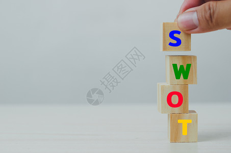的SWOT分析手工将木制立方体用于SWOT优势的弱点 在灰色背景上造成机会威胁背景