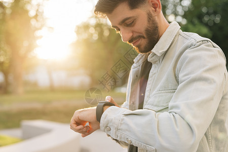 注册账号大胡子男子使用智能手表可穿戴腕带设备 男性检查脉冲智能手表应用程序 触摸屏可穿戴技术智能手环 商务人士在通知上滚动显示背景