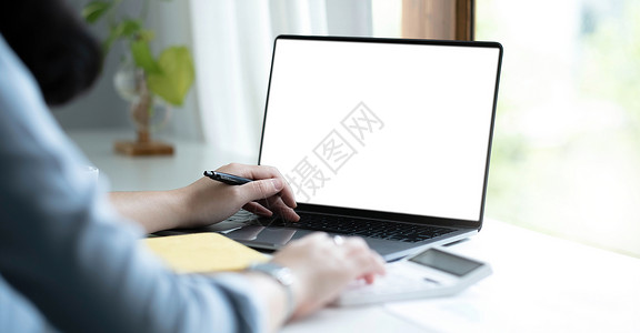 白键盘一名妇女用笔记本电脑在办公室的木制桌子上使用空白白屏屏幕键盘女孩技术监视器女性商业人士展示女士背景