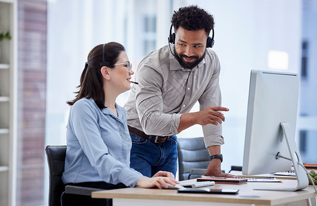 混血呼叫中心电话营销代理在办公室的电脑上培训新的白人助理 主管经理故障排除解决方案与实习生的客户服务和销售支持 同事一起操作服务背景图片