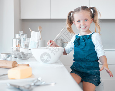 快乐的小女孩独自烘烤 白人儿童在她的厨房里烘烤 搅拌一碗面糊的年轻女孩的画像 小女孩喜欢在家烘烤 微笑的孩子烘烤背景图片
