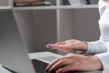 重要消息女商务人士在桌上的膝上型键盘上键入最近的更新 并手握重要的想法 办公室里的女人在电脑上写迟来的消息并显示新闻男性桌子技术全球成功背景