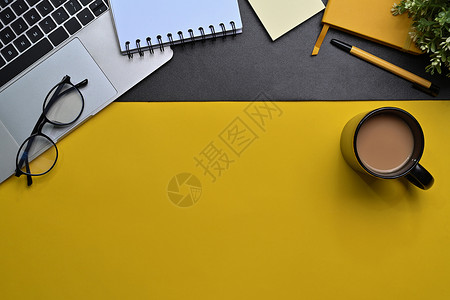黄色眼镜上面有电脑笔记本电脑 咖啡杯和黄色背景的注纸背景