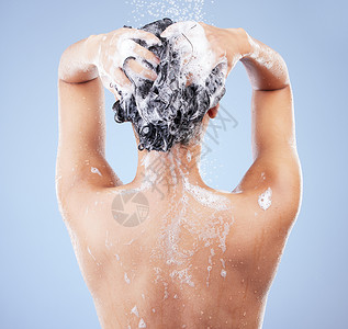 重要内容素材护发很重要 一个面目全非的女人在蓝色背景下淋浴时洗头背景