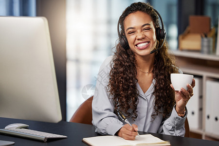 一名年轻女性呼叫中心工人在工作时喝咖啡 她每天要上班时间背景图片