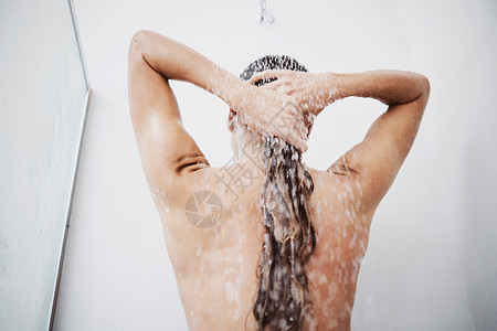 反复冲洗并封住那些小可爱 一个在淋浴时洗头发的女人背景