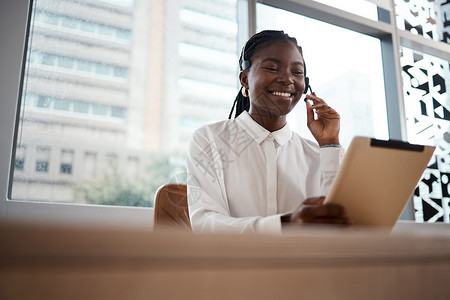企业的目的是创造和留住客户 一位女士在呼叫中心工作时使用数字平板电脑背景