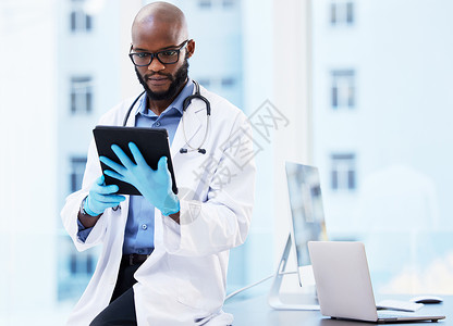 我需要更多空间嗯 我需要做更多的研究 一个英俊的年轻医生 独自坐在他的诊所里 用数字平板电脑背景
