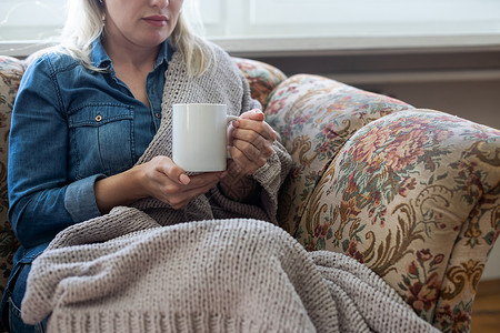 握着蓝杯茶或咖啡的手举近手 模特和舒适的格子坐在家里 在沙发上放松杯子早餐女性蓝色太阳女士中性色可可女孩饮料背景图片