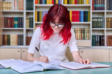 染成红色的头发在图书馆班学习的青少年女学生人数 女生大学研讨会考试眼镜写作学生教育课程项目阅读背景