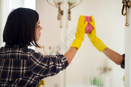女孩在用洗涤剂洗镜子工作抹布洗手间快乐女佣清洁工脸盆手套卫生家政图片