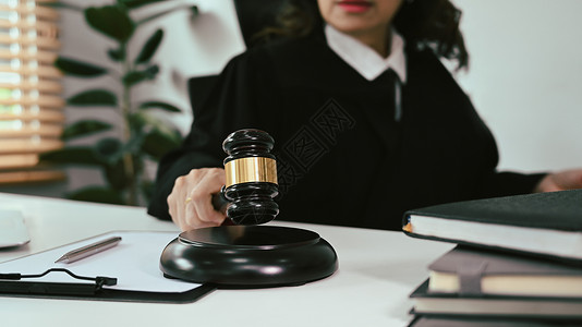 成熟法官手持木槌锤与客户交谈以提供法律咨询 在线法律咨询的剪影图片