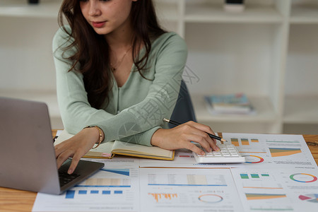 商业女商务人士分析公司的财务制度和书面文件在案头上计算女性商务管理人员人士会计咨询就业利润营销背景图片